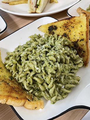 pesto fusilli pasta with bread on a plate